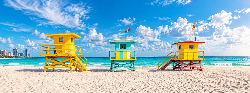 Yellow and turquoise lifeguard towers on a South Beach shoreline